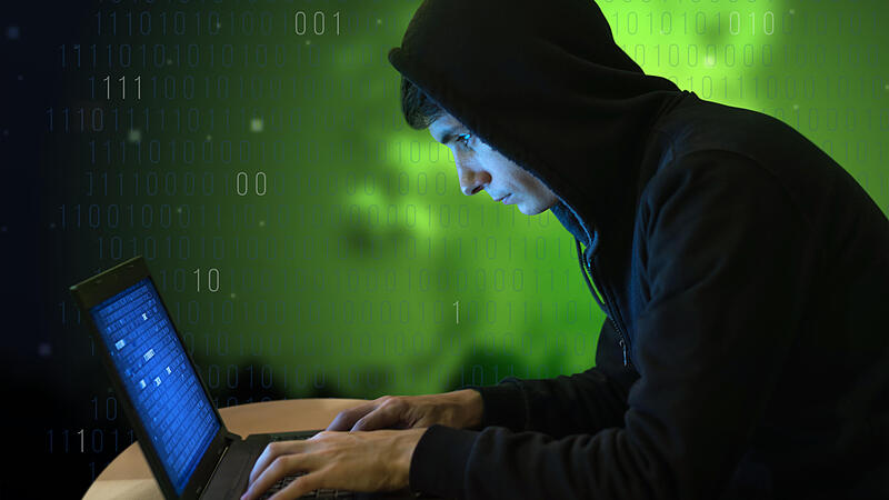 Hacker with laptop initiating cyber attack,a